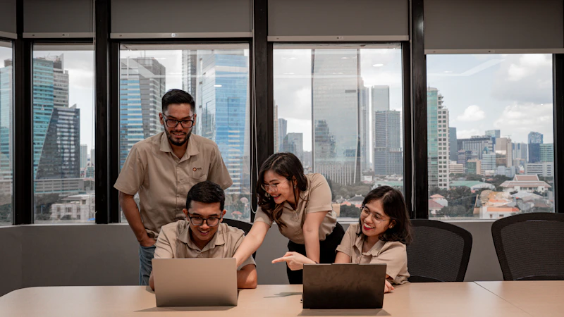 Ein Team arbeitet gemeinsam an Laptops in einem modernen Büro.